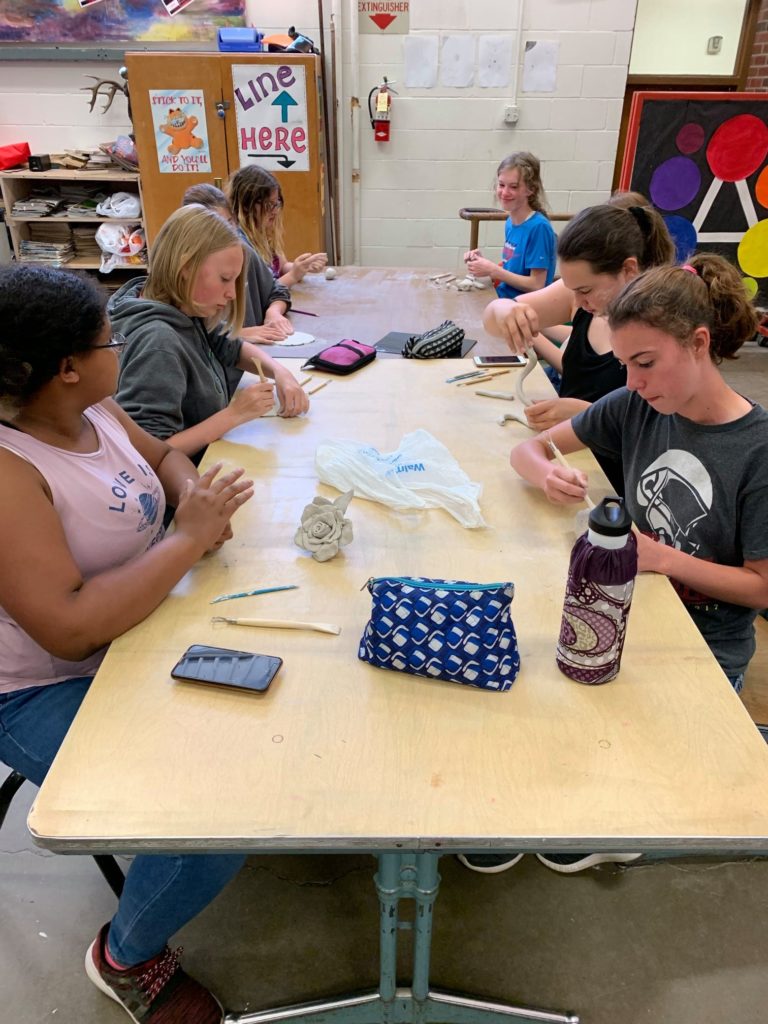 students building small clay statues